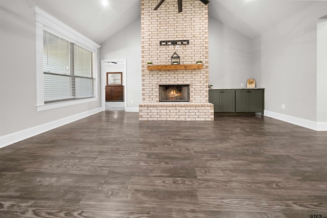 unfurnished living room featuring dark hardwood / wood-style flooring, a brick fireplace, and vaulted ceiling