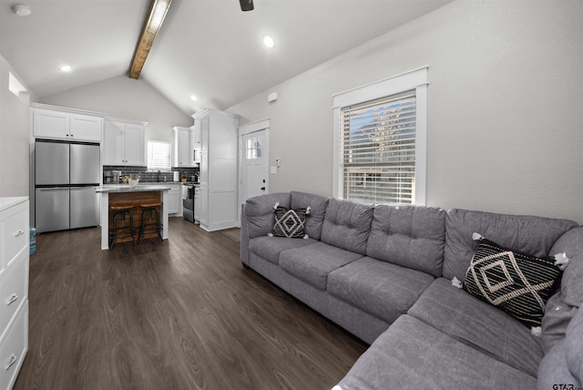 living room featuring vaulted ceiling with beams and dark hardwood / wood-style flooring