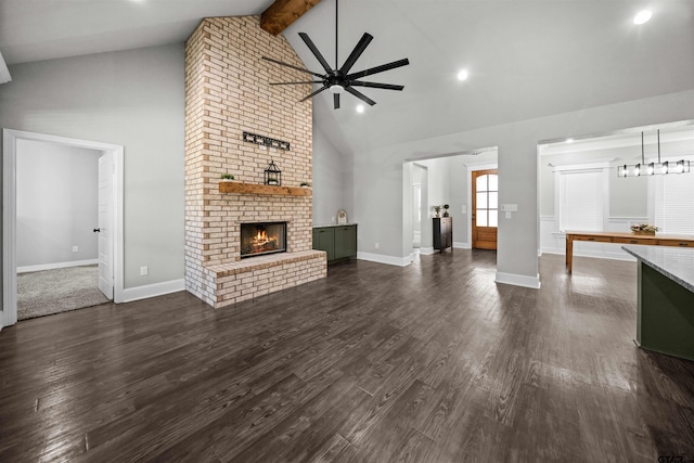 unfurnished living room with ceiling fan, dark wood-type flooring, a brick fireplace, beamed ceiling, and high vaulted ceiling