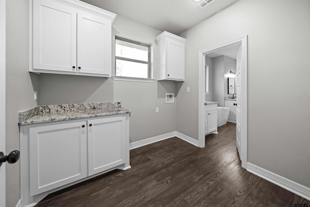 laundry room featuring cabinets, dark hardwood / wood-style floors, and washer hookup