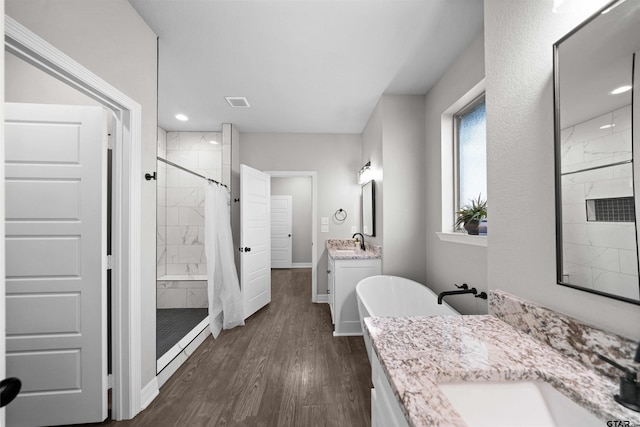 bathroom featuring hardwood / wood-style floors, vanity, and separate shower and tub