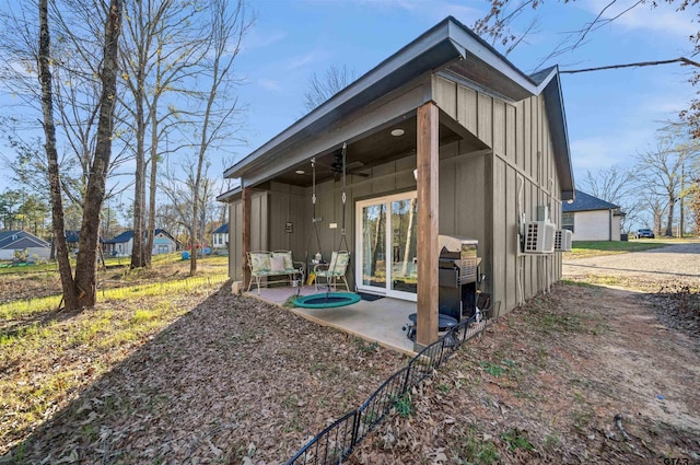 rear view of property with ceiling fan and a patio area