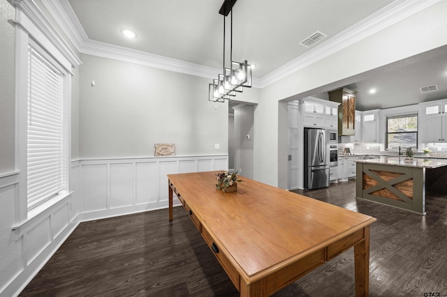 dining space featuring dark hardwood / wood-style floors, ornamental molding, and sink