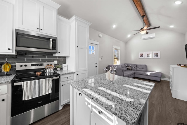 kitchen featuring white cabinetry, decorative backsplash, lofted ceiling with beams, and appliances with stainless steel finishes