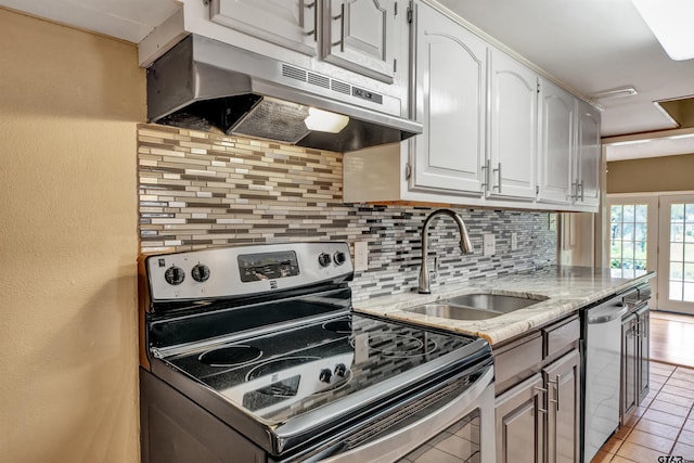 kitchen featuring sink, light tile patterned floors, appliances with stainless steel finishes, tasteful backsplash, and white cabinetry