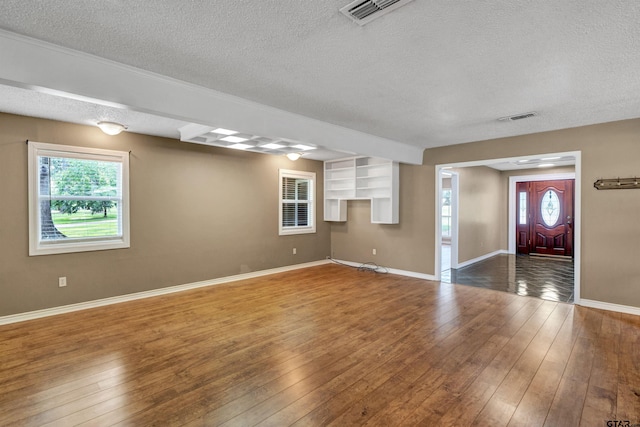 unfurnished living room featuring a textured ceiling and hardwood / wood-style flooring