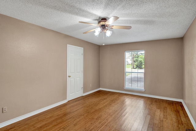 empty room with ceiling fan, a textured ceiling, and hardwood / wood-style flooring