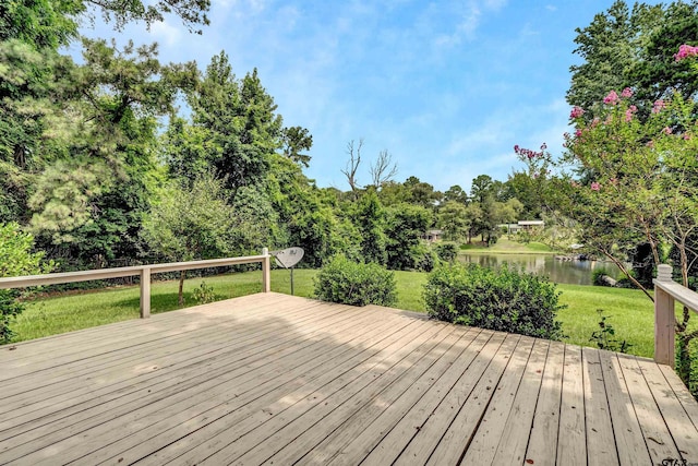 wooden deck with a lawn and a water view