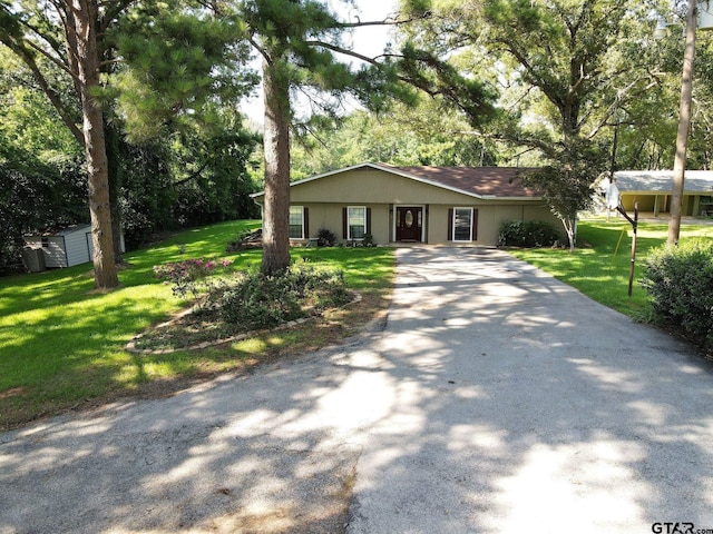 single story home featuring a shed and a front yard