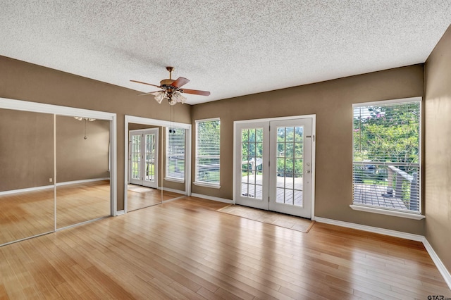 unfurnished bedroom featuring ceiling fan, light hardwood / wood-style floors, and a textured ceiling