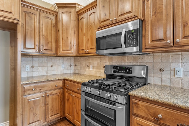 622 Martin, Chandler, TX 75758 - kitchen featuring stainless steel appliances, light stone counters, backsplash, and brown cabinets