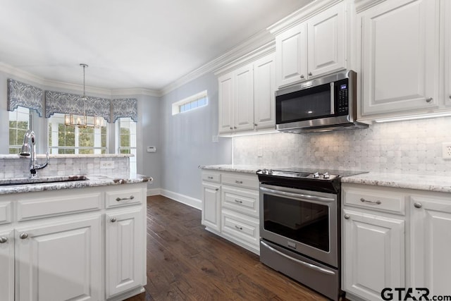 kitchen featuring a sink, white cabinetry, ornamental molding, appliances with stainless steel finishes, and dark wood-style floors