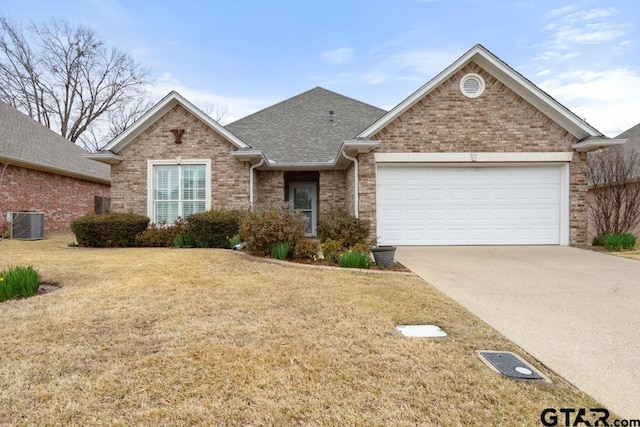 single story home featuring central air condition unit, a garage, brick siding, driveway, and a front yard