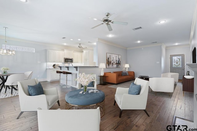 living room featuring recessed lighting, light wood-type flooring, visible vents, and crown molding