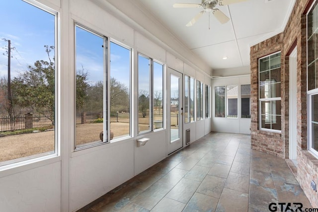 unfurnished sunroom with ceiling fan and plenty of natural light