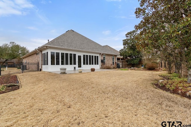 back of house featuring a fenced backyard, a lawn, and brick siding