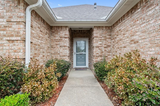 property entrance with brick siding and roof with shingles