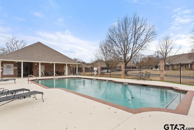 pool with a patio and fence