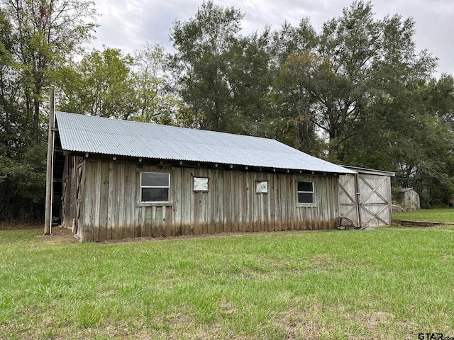 view of outbuilding featuring a lawn