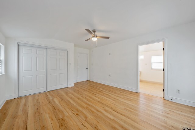 704 W 3rd St, Tyler, TX 75701 - unfurnished bedroom with light wood-style flooring, a closet, a ceiling fan, and connected bathroom