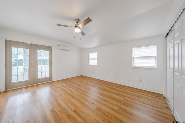 704 W 3rd St, Tyler, TX 75701 - unfurnished bedroom with french doors, an AC wall unit, light wood-type flooring, access to exterior, and vaulted ceiling