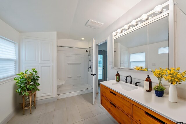 704 W 3rd St, Tyler, TX 75701 - bathroom featuring tile patterned floors, a shower stall, vanity, and vaulted ceiling