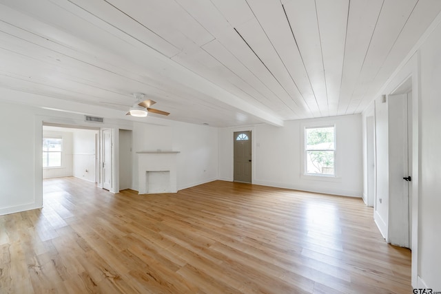 704 W 3rd St, Tyler, TX 75701 - unfurnished living room featuring plenty of natural light, light wood finished floors, a ceiling fan, a fireplace, and wood ceiling