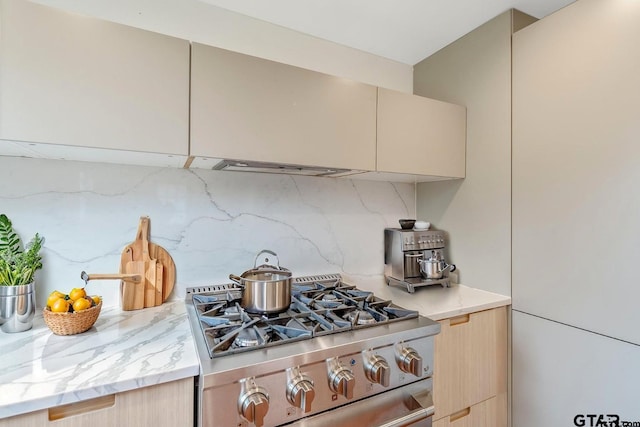 704 W 3rd St, Tyler, TX 75701 - kitchen with stainless steel range with gas stovetop, backsplash, modern cabinets, and light stone counters