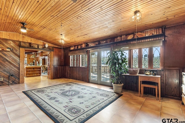 sitting room featuring vaulted ceiling, wood ceiling, plenty of natural light, and wooden walls