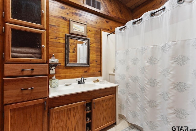 bathroom featuring vanity and wooden walls