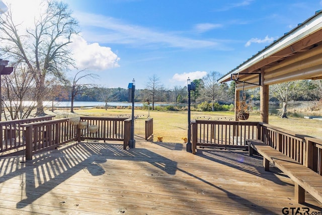 deck with a water view and a yard