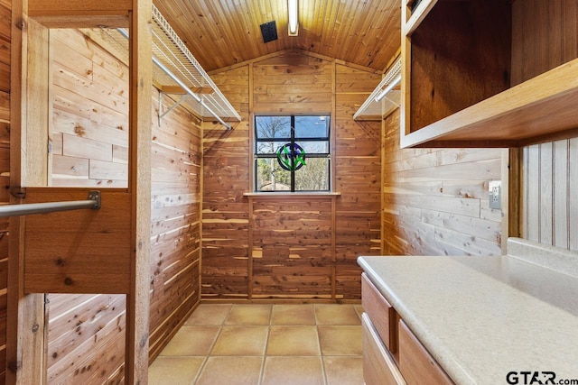 interior space with vaulted ceiling and light tile patterned floors