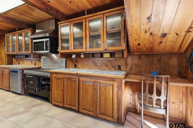 kitchen featuring light tile patterned floors, beam ceiling, and tile countertops