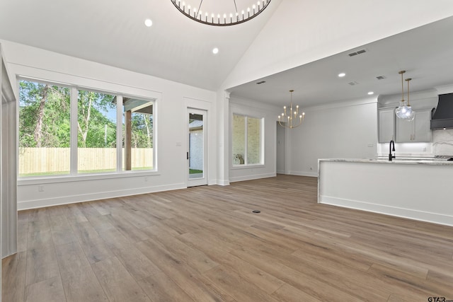 815 Redwing Way, Whitehouse, TX 75791 - unfurnished living room featuring a chandelier, recessed lighting, light wood finished floors, baseboards, and a sink