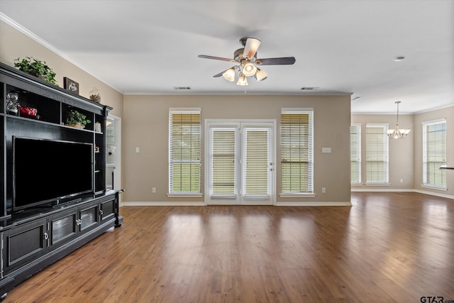 unfurnished living room featuring dark hardwood / wood-style flooring, ornamental molding, and ceiling fan with notable chandelier