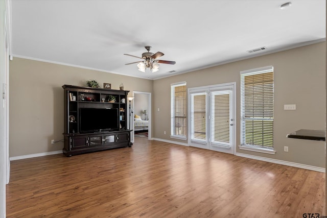 unfurnished living room featuring hardwood / wood-style floors, ceiling fan, and crown molding