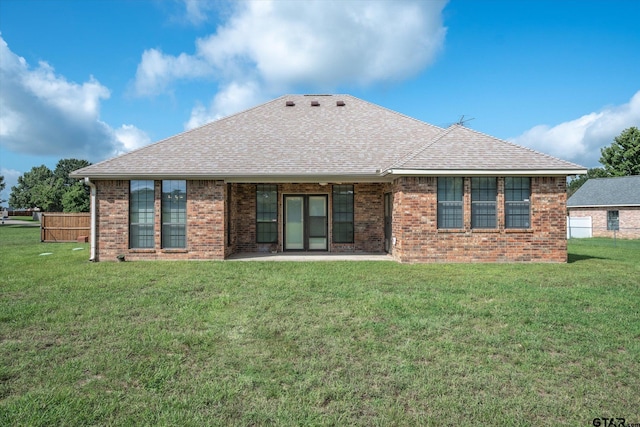 back of house featuring a lawn and a patio area