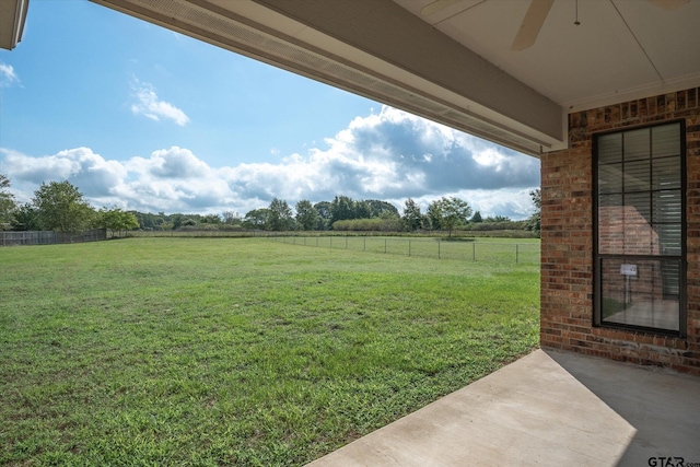 view of yard with a rural view, ceiling fan, and a patio