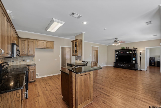 kitchen featuring kitchen peninsula, tasteful backsplash, ornamental molding, black range with electric cooktop, and light wood-type flooring