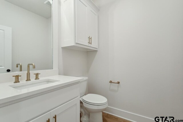 7201 Rolling Acres, Tyler, TX 75707 - bathroom with vanity, baseboards, toilet, and wood finished floors