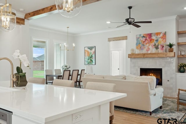 7201 Rolling Acres, Tyler, TX 75707 - kitchen featuring a chandelier, light wood-style floors, a ceiling fan, a fireplace, and pendant lighting