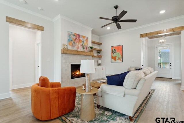 7201 Rolling Acres, Tyler, TX 75707 - living room with light wood finished floors, recessed lighting, a tiled fireplace, baseboards, and crown molding