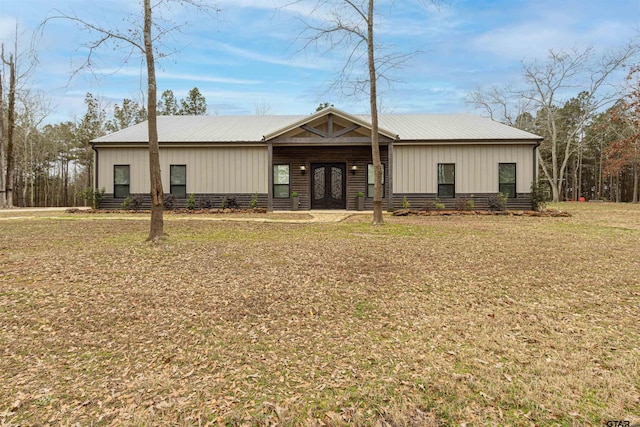 view of front of home featuring metal roof, board and batten siding, and a front yard