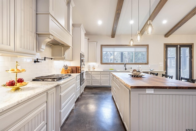 1490 Fm 13 E, Troup, TX 75789 - kitchen with wooden counters, finished concrete floors, beamed ceiling, decorative backsplash, and appliances with stainless steel finishes