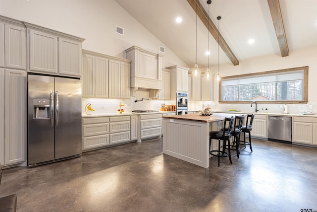 1490 Fm 13 E, Troup, TX 75789 - kitchen featuring appliances with stainless steel finishes, finished concrete flooring, decorative backsplash, a kitchen island, and a breakfast bar area
