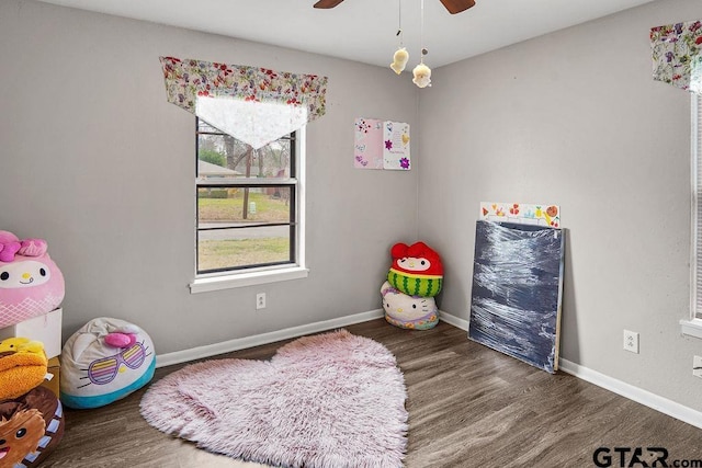 game room featuring dark wood-type flooring and ceiling fan