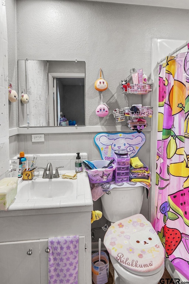 bathroom with vanity, toilet, and backsplash