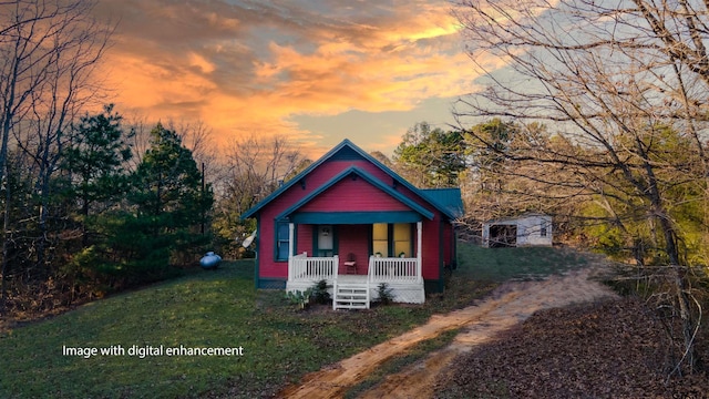 view of front of house featuring a porch and a storage shed