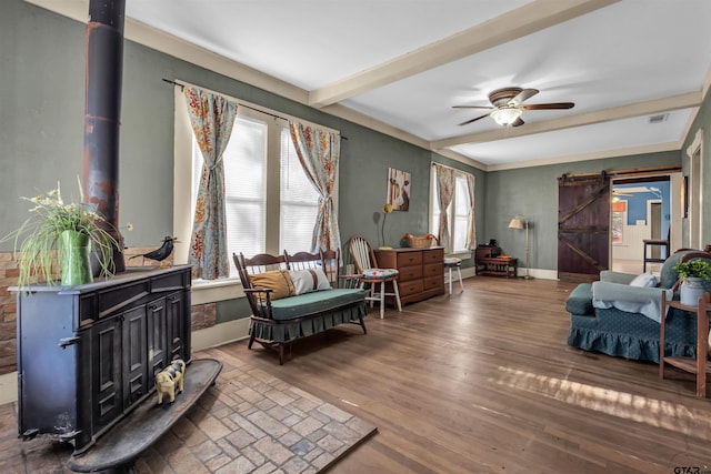 living room with a barn door, a wood stove, a wealth of natural light, and dark wood-type flooring