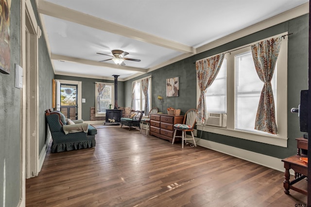 living area featuring dark hardwood / wood-style floors, a wood stove, cooling unit, and ceiling fan